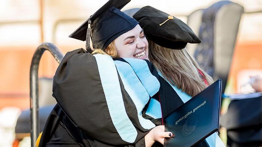 Graduating students hug